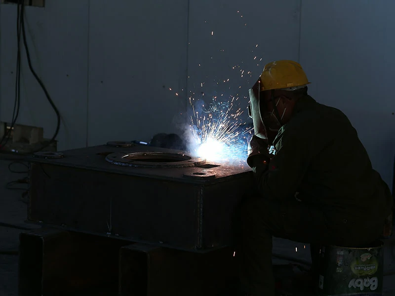 LS hydraulic press workshop worker performing welding operation